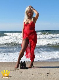 Lady Ewa : In einem transparenten roten Kleid, Nylons und hochhackigen Pumps besucht die Lady einen einsamen Ostseestrand. Und weil es so schön warm ist, zieht sie erst ihr Kleid aus und badet mit Nylons im Meer. Dann zieht sich die Polengöttin sich splitternackt aus und zeigt breitbeinig im Sand ihre rasierte Muschi.