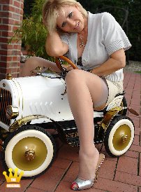 Lady Barbara : No, this is not my new car. In this series I show 7 inch high mules to you in shiny red and silver. See how my red painted claws are drilling through the sheer nylon stocking and protrude in in the toe opening. Not at the car, but at me.