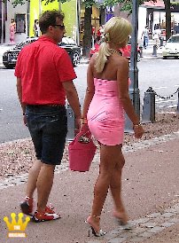 Lady Ewa : In an ultra-short and super-tight mini dress without underwear Lady Ewa is tottering with 14 cm high mules over the Königsallee in Dusseldorf. She is accompanied by a member who loves to present her in public. The young man massages the again and again the strained feet of the blonde Polish in on a park bench and in a telephone booth. Several times during her walk, the sexy Lady is thoroughly nudged by walkers.