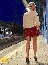 Lady Katinka : Lady Katinka presents herself in the evening in a white blouse and a tartan mini-skirt on an S-Bahn station near Bonn. On her bare feet, the chief secretary wears today red and black platform mules with 15cm heels. These are for sale. If you are interested, make a bid for the mules 5711.